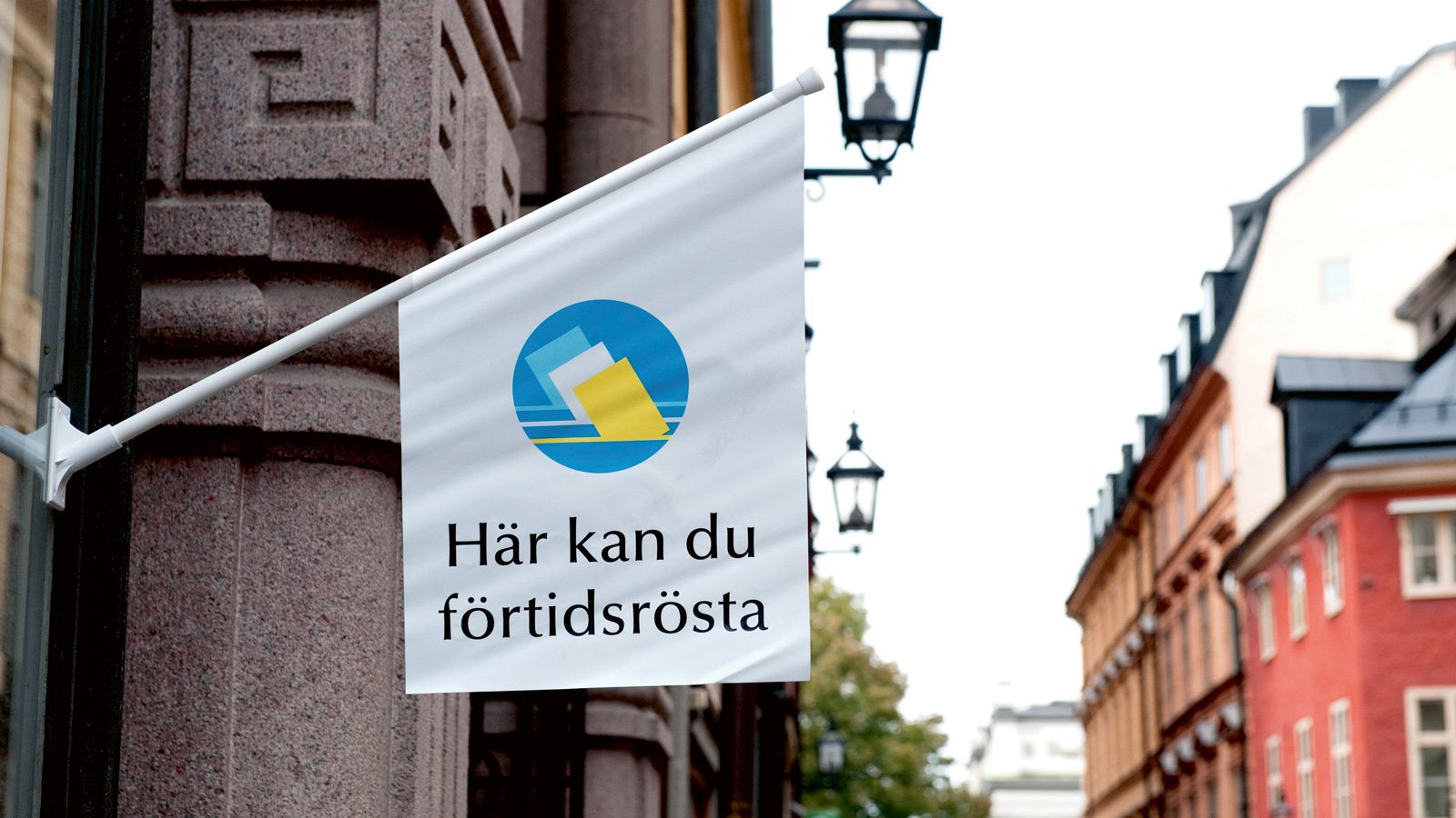 Flagga utanför en byggnad med texten Här kan du förtidsrösta